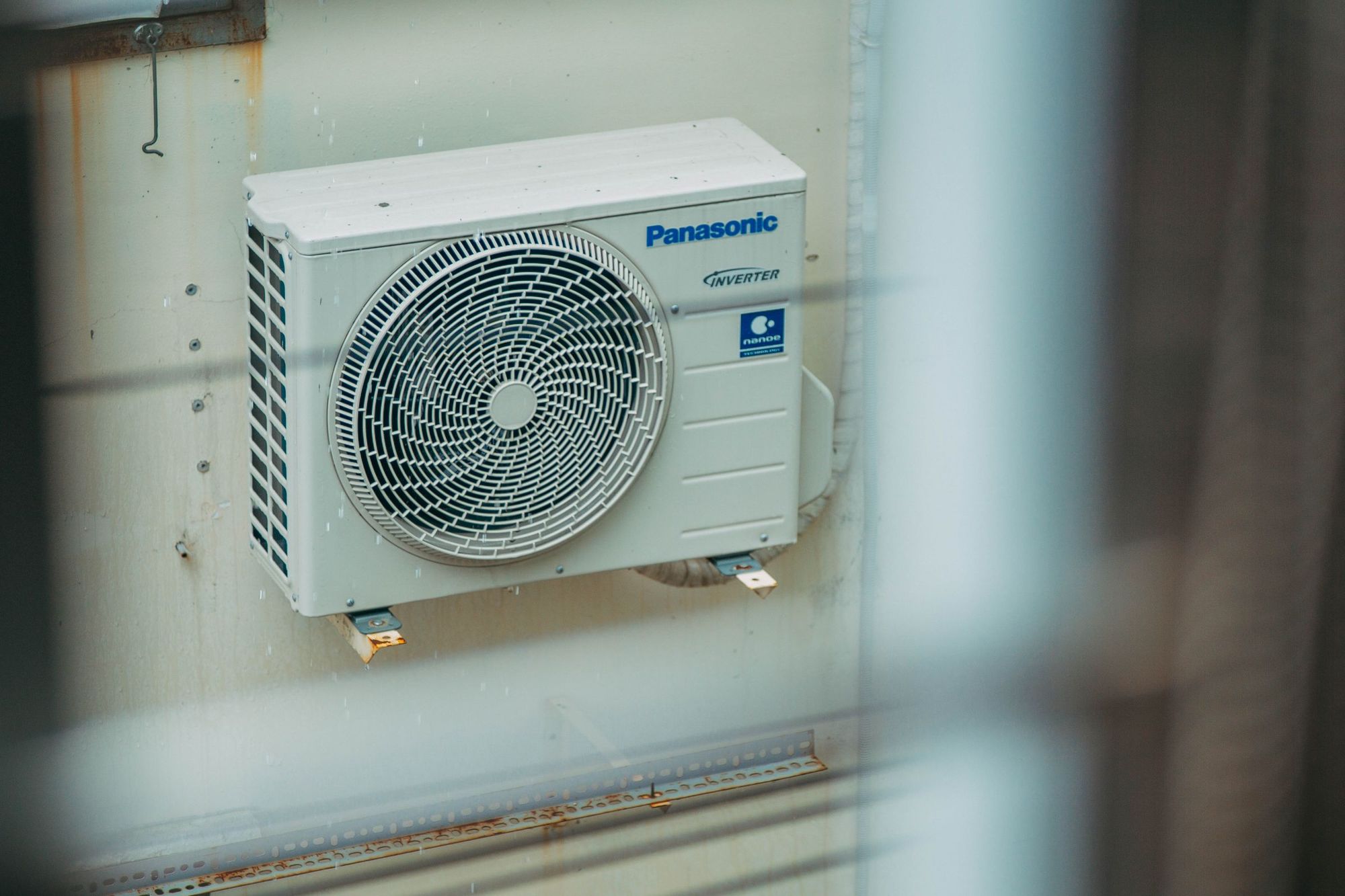 An outdoor ductless mini-split unit mounted on a building wall