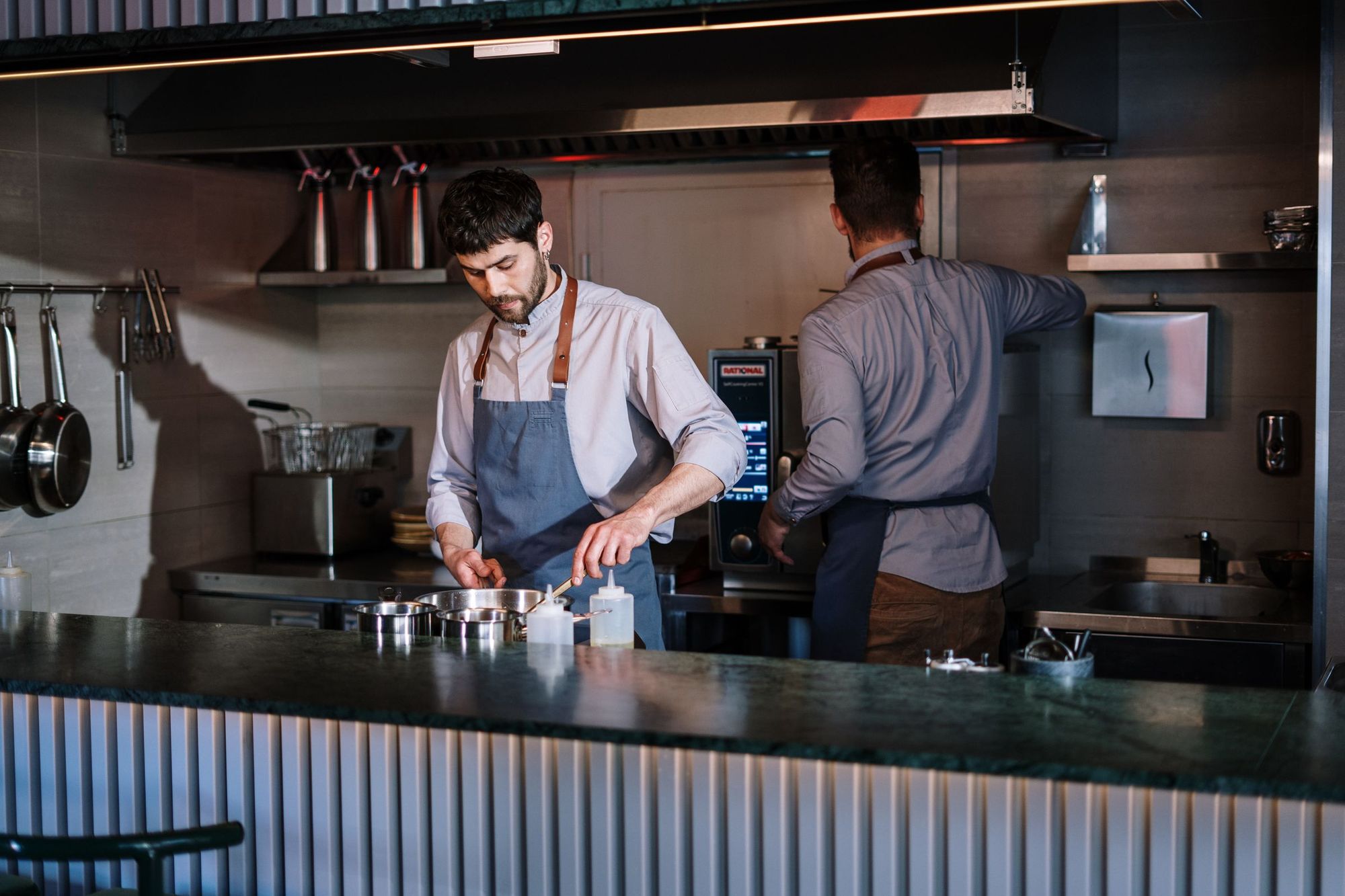Two chefs working in a busy commercial kitchen